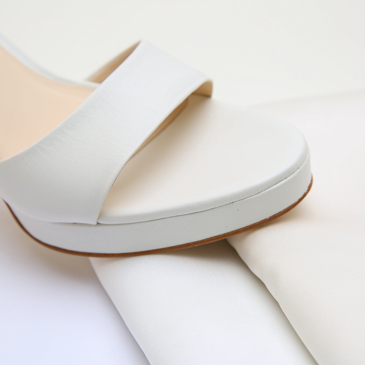 White Lo Platform by Alterre, featuring leather upper and lining, composite leather sole, a 3.5-inch heel and 1/2-inch platform, a cushioned foam insole, and interchangeable strap compatibility.