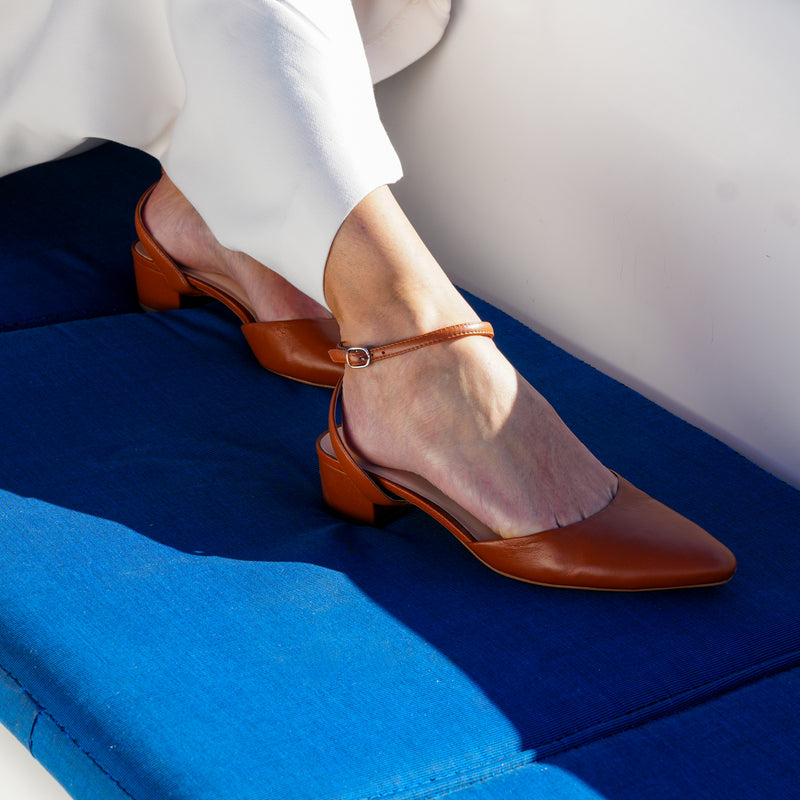 Cognac Slide with Marilyn cross-back straps by Alterre, a sleek brown leather sandal designed for customizable styling and all-day wear.